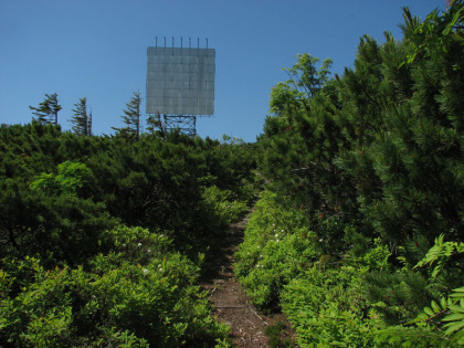 反射板。登山の途中の最初の休憩地に適しています。なだらかなピークの上に反射板が建っています。