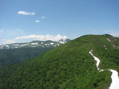 天狗岳から見た有明山（手前）と雪が残る平山連山。最奥は表大雪。