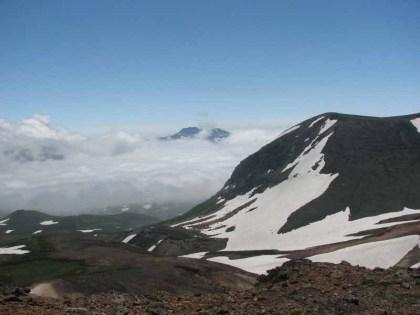 雲上に頂を見せるトムラウシ山