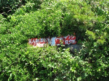 ところどころにある標識、朽ちていて地面に置かれているので草に隠されています、この標識は「天人峡まで８．５ｋｍ、トムラウシまで８．０ｋｍ」と書かれています