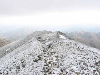 吹きさらしのの山頂。まっすぐ立つことが出来ないので、斜めの姿勢でようやく風に吹き飛ばされないと言った強風が吹き荒れていました