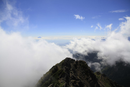 八ヶ岳の山頂から見た雲の上に浮かぶ富士山。