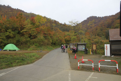 雨飾高原の登山口。舗装路と東屋の間にあります。入山届けは東屋に設置されています。