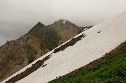 雪渓の脇の岩場を登って行きます。