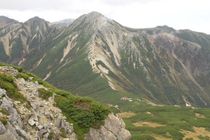 三俣蓮華岳から見た鷲羽岳。鷲羽乗越に三俣小屋が見えます。