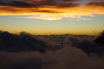 朝焼け。低い雲と高い雲の間にわずかに雲の断層があって、朝日の光がその間から差し込んでいます。