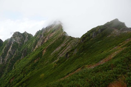 赤沢岳に伸びる稜線。東がわ（右）は崩落して崖となっています。西がわ（左）は黒部の谷に落ちる急斜面。東の風が稜線に当たって雲を湧き立たせていました。