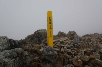 鑓ヶ岳の山頂。これだけ雨風が強く気温も下がっているときは、ピークは巻いて先に進みたいのですが、鑓ヶ岳には巻き道がありません。杓子岳は巻いて通りました。