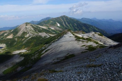 鉢ヶ岳（左手前）と雪倉岳（中央奥）。東風で湧く雲の移動が早いので、負けない様にペースを上げて、稜線の道を雪倉岳に上りました。