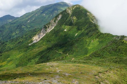 赤男山の鞍部。山の西がわを大きく巻きます。後に朝日岳が見えます。