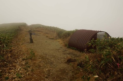 一ノ倉岳の山頂。中芝新道の分岐があり、避難小屋が建てられています。一ノ倉岳避難小屋は1人か2人が入るのがやっとの小さな建物です。