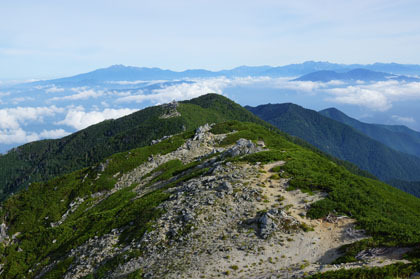 将棋頭山の山頂の先に乗鞍岳と穂高連峰があります。