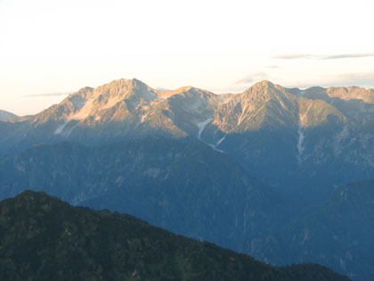 朝日に染まる立山三山の内の雄山と別山。