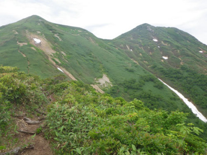 コルから見上げた笠ヶ岳（右）。
