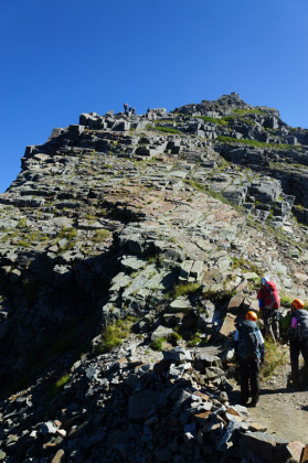 岸壁の上と下に登山者がいて、道を譲り合っている。