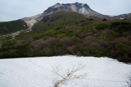 まだ雪に覆われているヒョウタン池越しに見る茶臼岳。