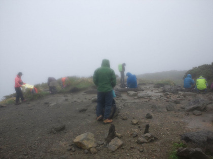 横風と雨の三本槍ヶ岳。丁度昼過ぎだったので、昼食を兼ねて休憩を取る登山者が多かった。